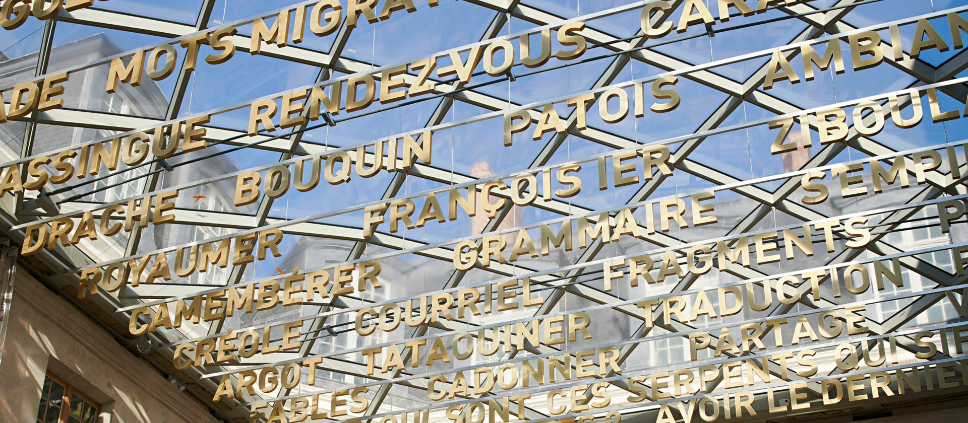palabras en francés colgando del techo de cristal de la Cité de la Langue Française