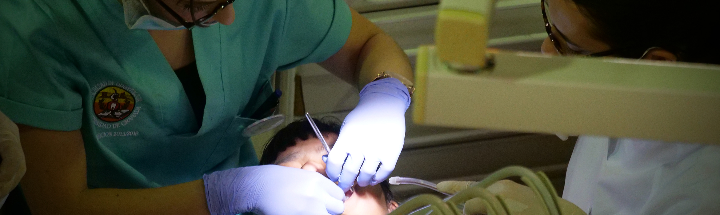 Estudiantes de la Facultad de Odontología examinando la boca a un paciente