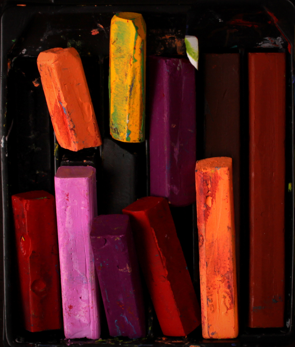 En la imagen se ve un conjunto de ceras pastel de diversos colores usadas y deterioradas