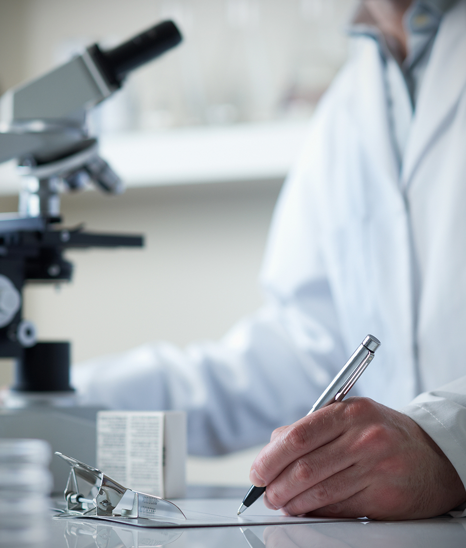 Un investigador rellena un documento tras la utilización de un microscopio de laboratorio